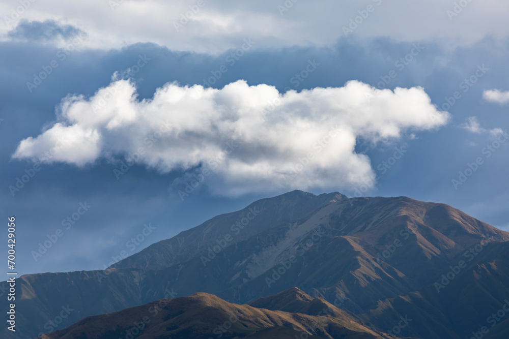Photograph of a mountain range covered in low level grey clouds on the South Island of New Zealand