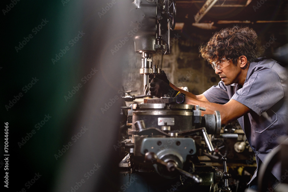 Asian worker in production plant drilling at machine. Professional worker near drilling machine on factory. finishing metal working internal steel surface on lathe grinder machine with flying sparks. Asian worker in production plant drilling at machine. Professional worker near drilling machine on factory. finishing metal working internal steel surface on lathe grinder machine with flying sparks.