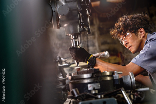 Quadro su tela Asian worker in production plant drilling at machine