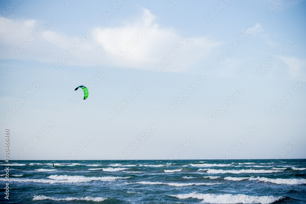 Sportsman kitesurfing on sea waves Sportsman kitesurfing on sea waves