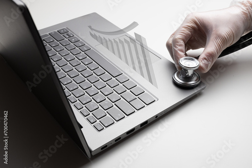 Notebook with regressive graph, hand with stethoscope on white b photo