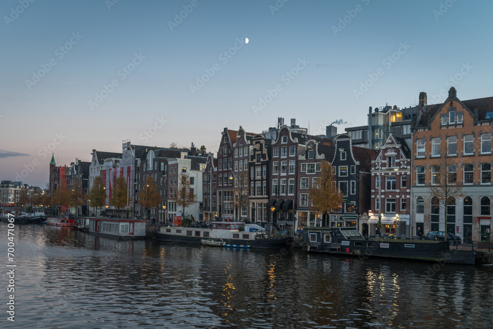 Morning half moon over Amsterdam canal and houses