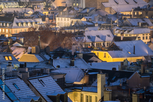 Evening winter scene with snowy roofs and city lights in Zurich © Cavan