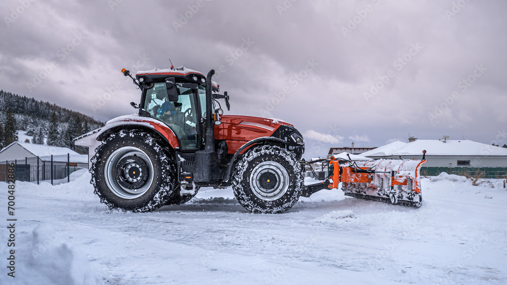 The snow plow tractor while snow clearing on the street. The snow plow tractor while snow clearing on the street.