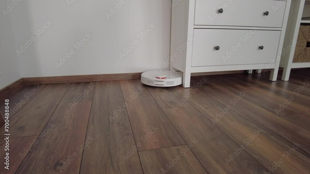 Vacuum Robot cleaning at home. Robot vacuum cleaner in the modern home. Smart cleaning technology Vacuum Robot cleaning at home. Robot vacuum cleaner in the modern home. Smart cleaning technology