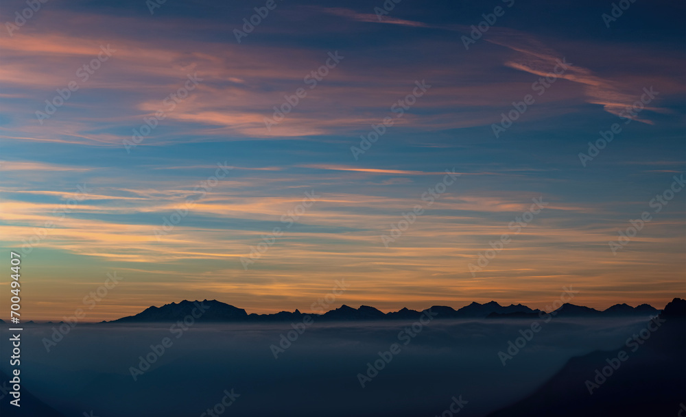 Sunset over the clouds with Monte Rosa massif on the horizon