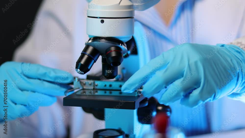 Female doctor or scientist in laboratory looking at microscope. Female doctor or scientist in laboratory looking at microscope.