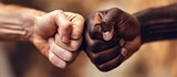 Closeup photo of two arms different race skin colors multinational friends antiracism issue help together buddies world globe integration giving fists bump isolated grey color background