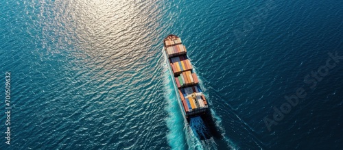 Aerial drone photo of industrial colourful vessel carrying heavy truck size containers cruising the Aegean deep blue sea. Creative Banner. Copyspace image photo