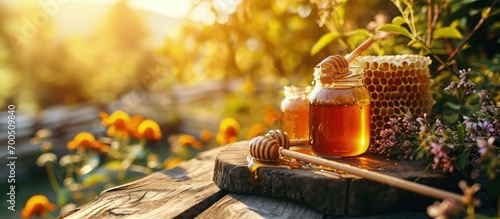Honey in honeycombs top view Fresh honey in honeycombs lies in a bowl on a wooden table close up on a summer sunny day Organic honey production Beekeeping as natural traditional agriculture photo