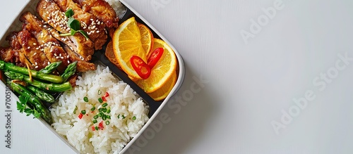 Fried pork topping on Jasmine rice with asparagus ginger and orange flavor cake in the ready to eat lunchbox. Creative Banner. Copyspace image photo