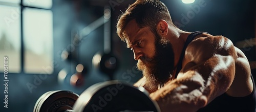 Full body shirtless bearded sportsman preparing to lift hexagon dumbbell during functional workout in dim light of fitness center. Creative Banner. Copyspace image photo