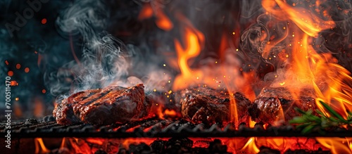 burning fire in compact grill wood logs engulfed red flames closeup of metal grill on burning coals aromatic smoke rises appetizingly fun party happy childhood family activity cooking outdoors