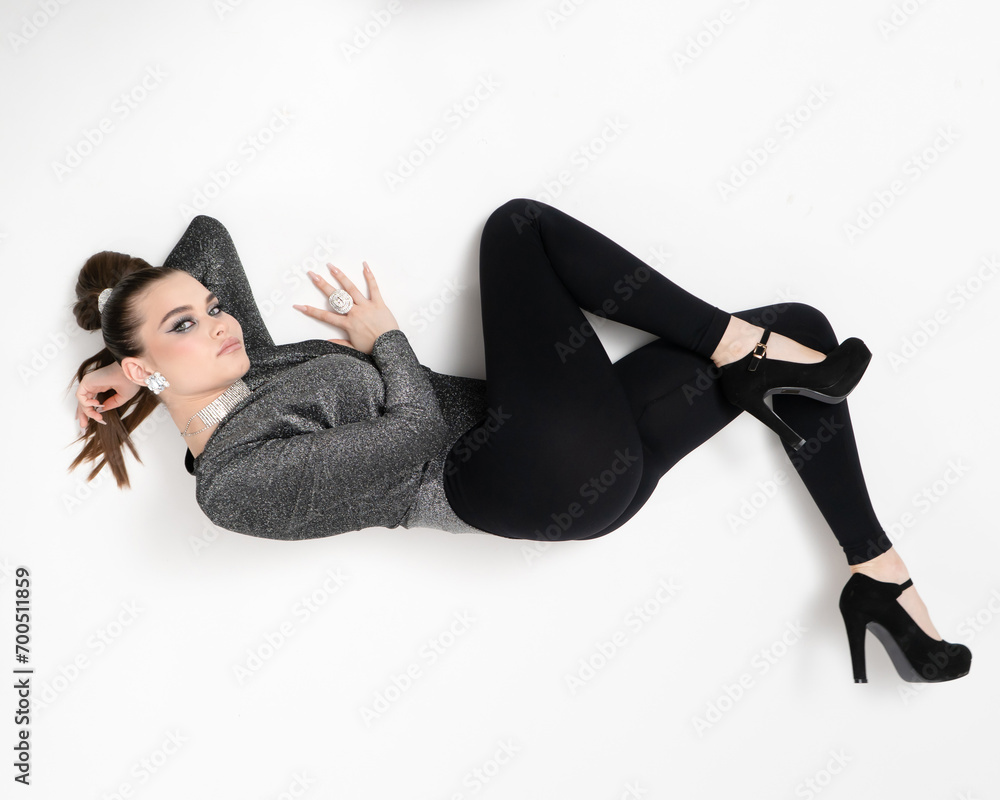 A girl poses lying in an unusual position on the floor and looking at the camera A girl poses lying in an unusual position on the floor and looking at the camera