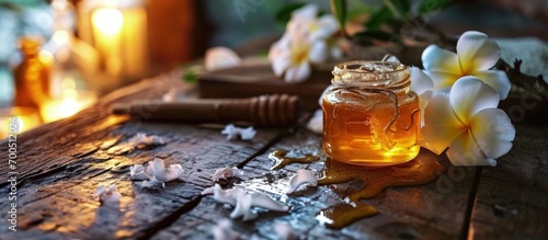 Glass jar of golden honey closep with frangipani flowers Preparing natural beauty body treatment at home sweet yellow sugar nectar facial mask. Creative Banner. Copyspace image photo