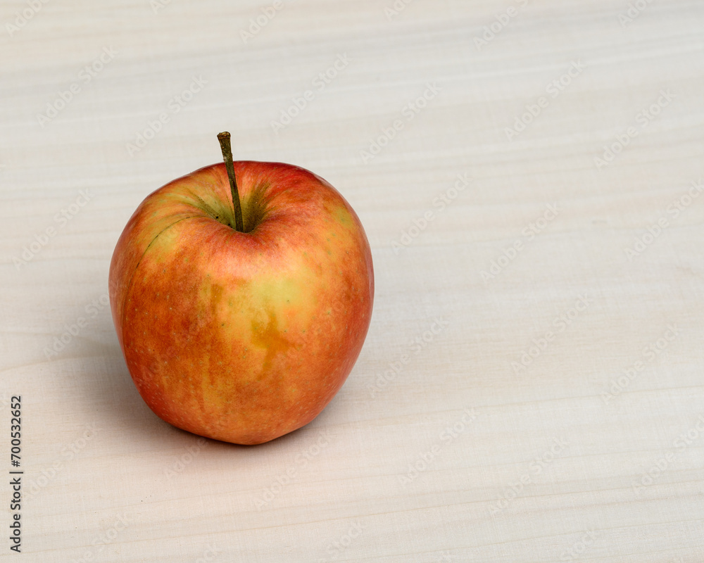 Jedno dojrzałe jabłko na drewnianym stole - obrazy, fototapety, plakaty 