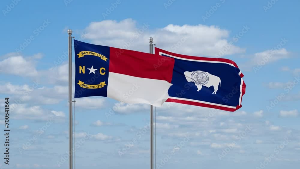Wyoming and North Carolina US state flags waving together on cloudy sky, endless seamless loop Wyoming and North Carolina US state flags waving together on cloudy sky, endless seamless loop