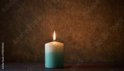  a lit candle sitting on a table in front of a brown wall with a shadow of the candle on the table and a brown wall in the background behind it.