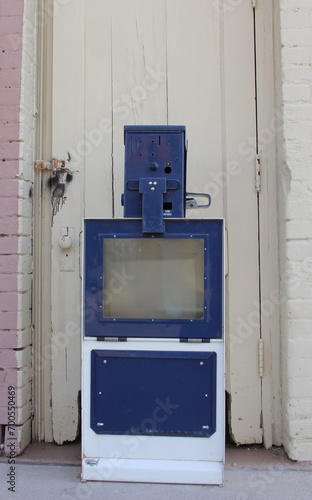Empty Newspaper Vending Machine on Sidewalk near store building