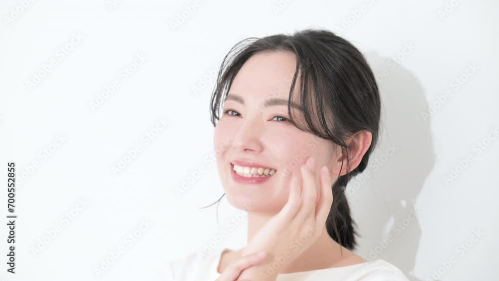 Busty, smiling, hand on cheeks, close-up, summarized hair, female beauty, white background, close-up slow-motion video. Busty, smiling, hand on cheeks, close-up, summarized hair, female beauty, white background, close-up slow-motion video.