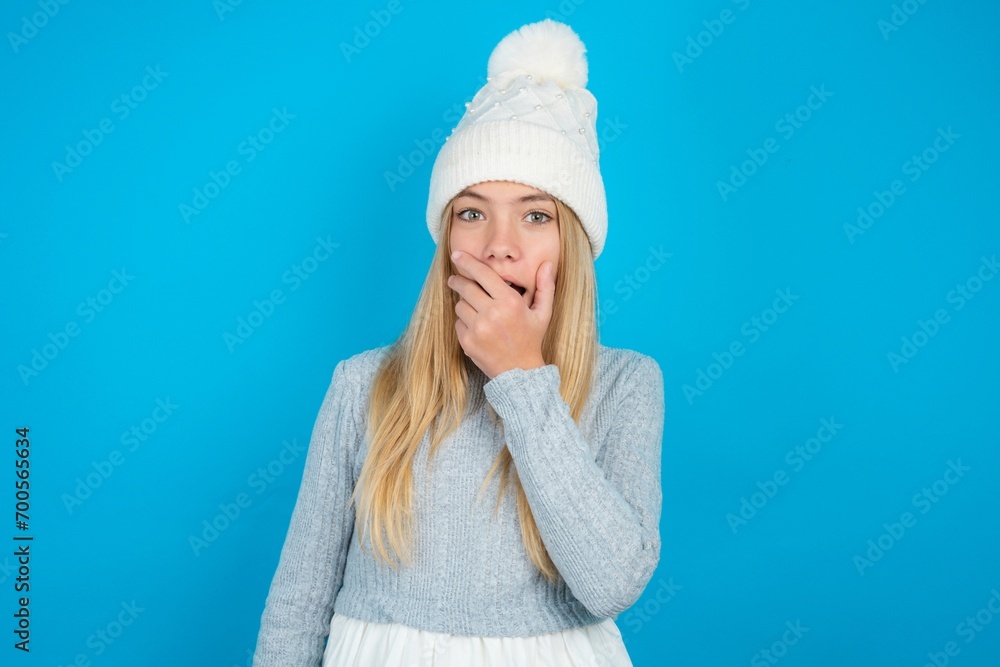 Φωτογραφία Emotional beautiful caucasian teen girl wearing grey sweater gasps from astonishment, covers opened mouth with palm, looks shocked at camera