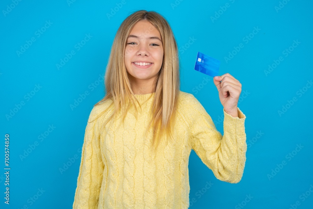 Photo of happy cheerful smiling positive beautiful caucasian teen girl wearing yellow sweater recommend credit card Photo of happy cheerful smiling positive beautiful caucasian teen girl wearing yellow sweater recommend credit card