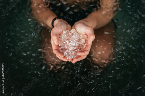 Holding a handful of ice blocks in an ice bath.