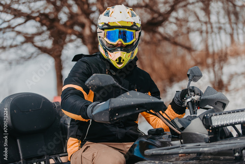 A man is fearlessly enjoying an adventurous ride on an ATV Quad through hazardous snowy terrain, embracing the thrill and excitement of the challenging mountainous landscape