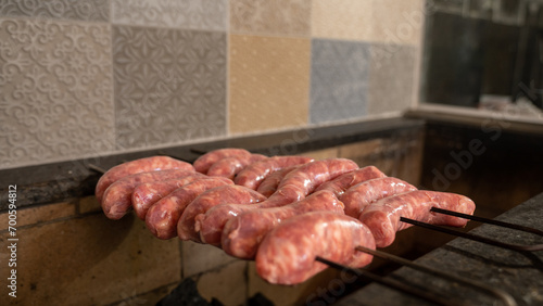 Close up of raw traditional Brazilian barbecue sausage being put on a stick for Traditional Churrasco Brazilian Barbecue. Put on a grill 