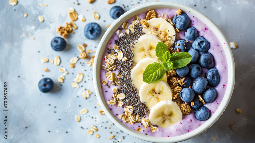 Сlose-up of a healthy vegan breakfast. A plate with healthy superfood - fresh berries, fruit yogurt, chia seeds, granola and banana slices on pastel table.  - obrazy, fototapety, plakaty 