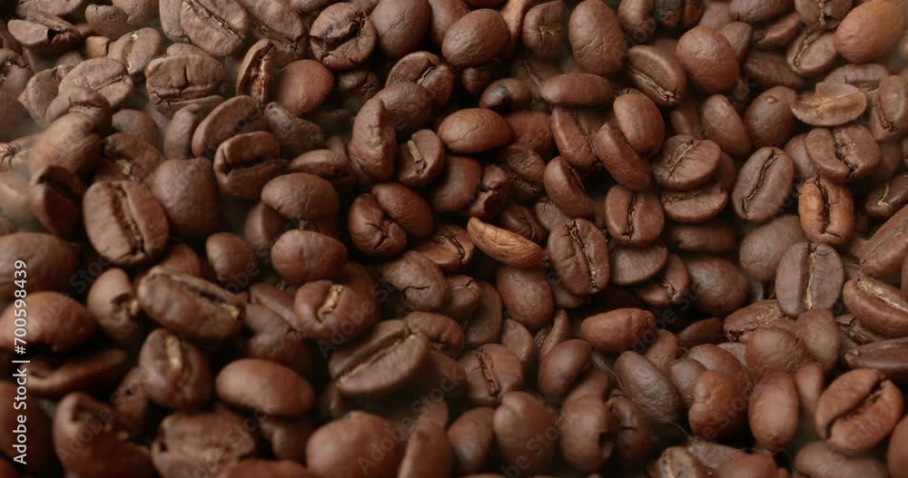 Close up of seeds of coffee. Fragrant coffee beans are roasted smoke comes from coffee beans. Close up of seeds of coffee. Fragrant coffee beans are roasted smoke comes from coffee beans.