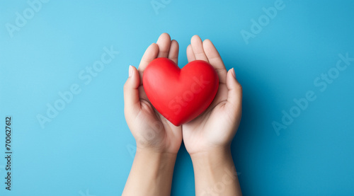 The essence of love with hands presenting a red heart on a serene blue background  an eloquent symbol of affection. Generative AI.