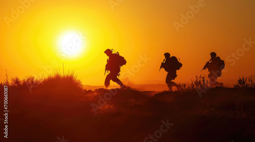 A suluette of military soldiers on a mission against a background of the walking sun outdoors