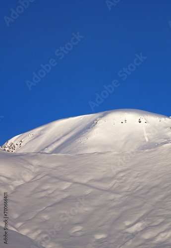 Off-piste slope and blue cloudless sky in nice winter morning