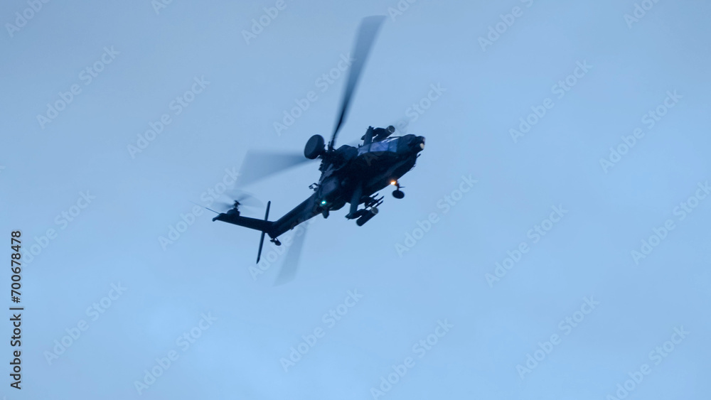 Fototapeta premium British army Boeing Apache Attack helicopter gunship (AH64E AH-64E ArmyAir606) banking hard in flight, Wiltshire UK