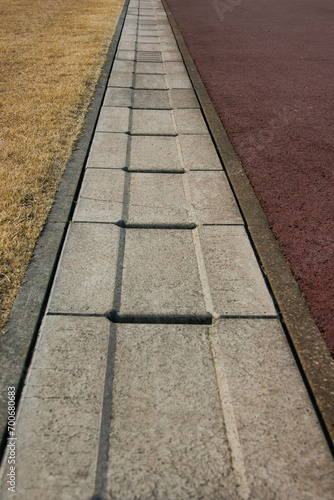 冬の公園の地面と芝生を分ける雨水の側溝