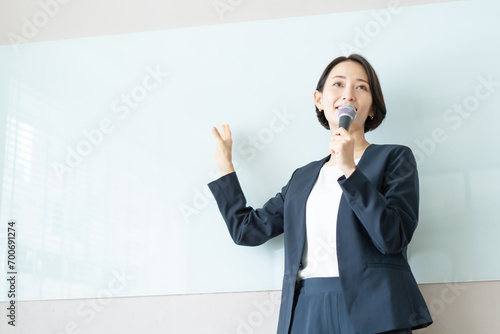 マイクを使ってプレゼンテーションを行う女性