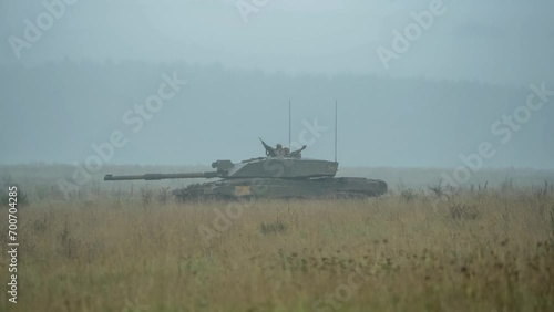 a stationary British army Challenger 2 II FV4034 main battle tank in action, turret swivelling, scoping for enemy targets in pouring rain. Wilts UK photo