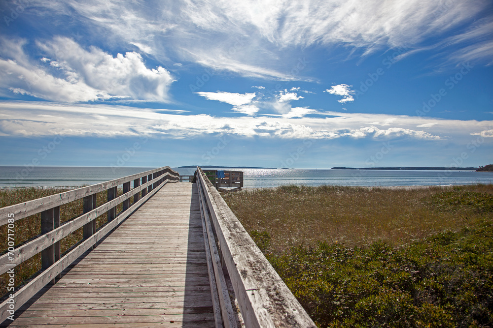 long wooden boardwalk leading to the atlantic ocean on a clear sunny day