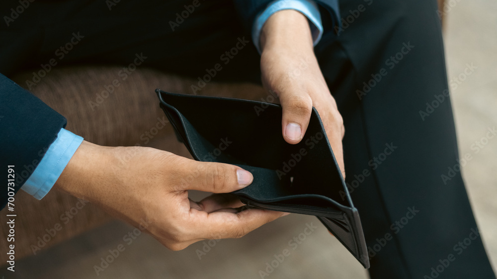 Poor man bankrupt with no credit in debt hand hold empty black leather wallet because economy down turn Empty wallet (no money) in the hands of an man