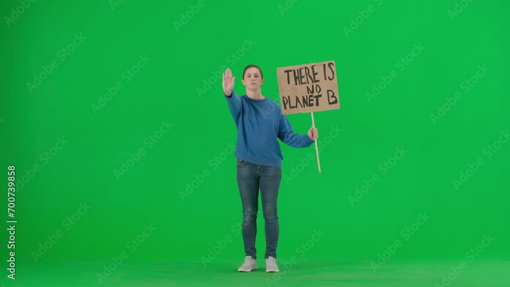 A young female activist shows a sign that says There is no planet B and makes a stop gesture with one hand. A woman in the studio on a green screen. Save the planet, global warming and climate change. A young female activist shows a sign that says There is no planet B and makes a stop gesture with one hand. A woman in the studio on a green screen. Save the planet, global warming and climate change.