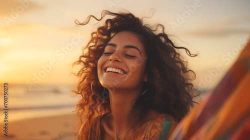 Gleeful Latin lady unwinding on shore with shut lids during dusk. Lovely multiracial lady savoring breeze tousling locks. Alluring youth inhaling crisp air at beach in summertime.