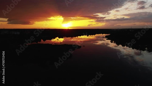 Majestic Sunset Silhouetting a Tranquil Marsh Landscape, Vibrant Colors Reflecting on Calm Waters photo