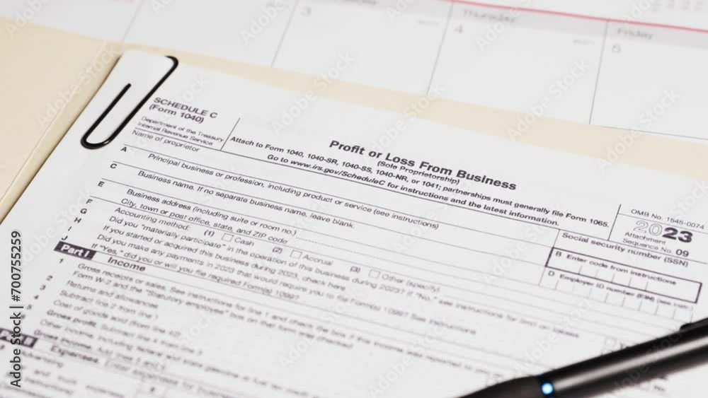 Schedule C tax form document on table Schedule C tax form document on table