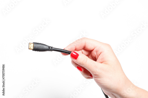 Two connectors for TV in hands with red manicure on white background