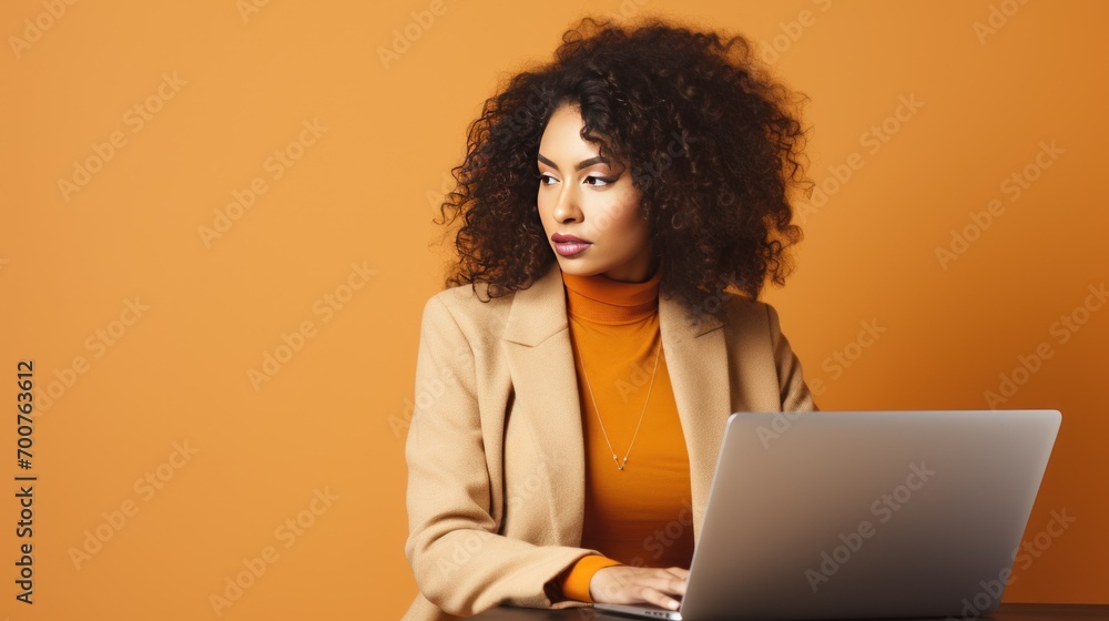 African american woman working with laptop isolated on orange