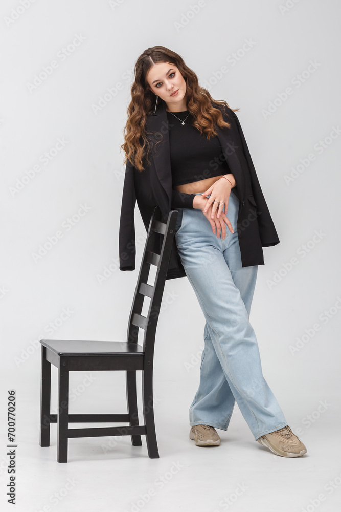 girl model in black shirt and blue trousers posing relaxed in studio girl model in black shirt and blue trousers posing relaxed in studio