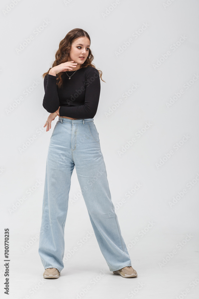 girl model in black shirt and blue trousers posing relaxed in studio girl model in black shirt and blue trousers posing relaxed in studio