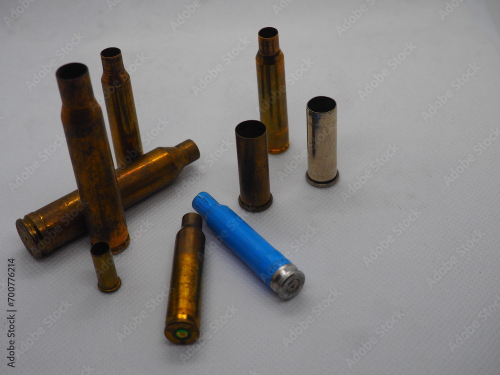 Cartridges, casings of golden and silver ammunition against black, blue, white, and green backgrounds Cartridges, casings of golden and silver ammunition against black, blue, white, and green backgrounds