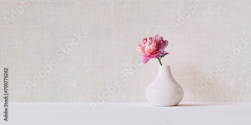 Fototapeta Naklejka Na Ścianę i Meble -  Simple and minimal springtime holiday decoration with ceramic vase and peony flower with textured plaster wall 3d rendering background.